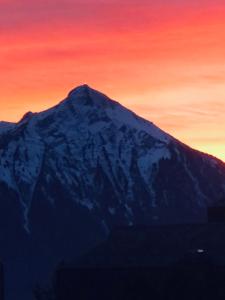 贝阿滕贝格Wohnung mit See und Bergsicht im vier Sterne Hotel的山地雪覆盖,背景是日落