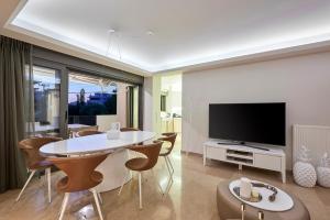 雅典格里法达艾莱亚豪华公寓的客厅配有桌子和电视