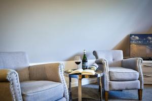 韦斯特兰兰道思新特汉旅馆的客厅配有两把椅子和一张桌子,并佐以一杯葡萄酒