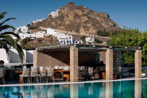 斯基罗斯岛内菲利酒店的一个带椅子的游泳池,后方是一座山