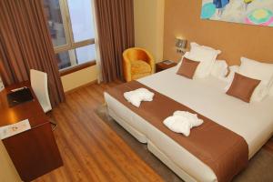 维戈阿瓜德玛尔精品酒店的酒店客房带一张大床,带毛巾