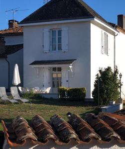 Oradour-FanaisGîte des Roses的院子里有一条鱼的白色房子