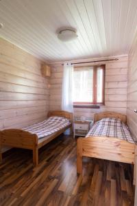 Korkeakoski库尔塔拉平房旅馆的木墙客房的两张床