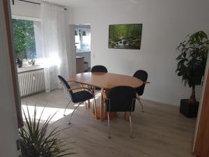 阿伦Ferienwohnung an der Klinge的一间带木桌和椅子的用餐室