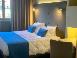 波尔图Vilar Oporto Hotel的一间卧室配有一张带蓝色枕头的大床