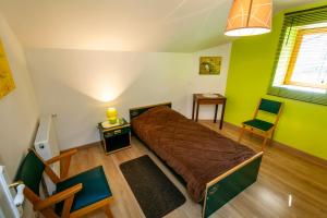 DevilleGîte " LE CHEMIN VERT "的一间设有床铺的卧室,位于一个拥有绿色墙壁的房间