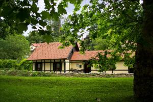 多布尔纳Hiška ob potoku的绿色田野上一座红色屋顶的房子