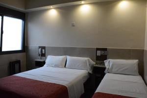 布宜诺斯艾利斯Hotel Santa Cruz的酒店客房设有两张床和窗户。