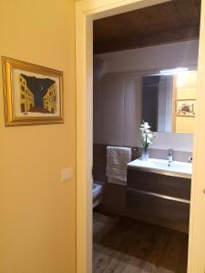 博萨Le Orchidee的一间带水槽、卫生间和镜子的浴室