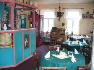 阿尔布勒茨缇策维基泽尔斯基弛霍拉次Jako doma的一间用餐室,配有两张带绿桌布的桌子
