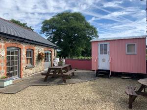 翰索Swallow Cottage at Duffryn Mawr Cottages的庭院设有野餐桌和棚子