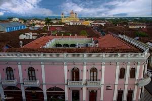 格拉纳达雷亚尔梅赛德酒店的一座粉红色的建筑,以城市为背景