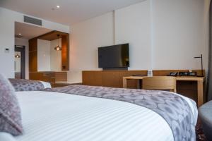 利物浦悉尼利物浦美居酒店的配有一张床和一台平面电视的酒店客房