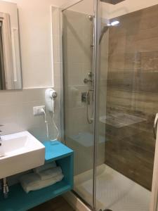 卡斯泰拉马莱Ai Gradini Affittacamere的一间带玻璃淋浴和水槽的浴室