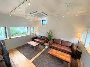 镰仓市B&B KAMAKURA的客厅配有两张真皮沙发和一张桌子