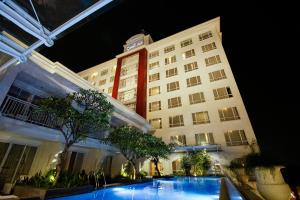 塞尔蓬大祖里BSD城市酒店的大楼前设有游泳池的酒店