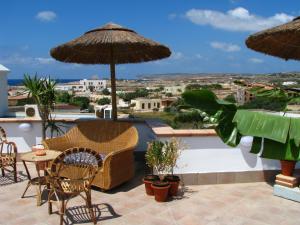 兰佩杜萨伊尔法洛德拉贵加托玛西诺酒店的一个带桌椅和遮阳伞的庭院