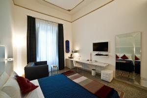 雷焦卡拉布里亚城镇之屋凯沃尔酒店的酒店客房设有一间带书桌和床的卧室