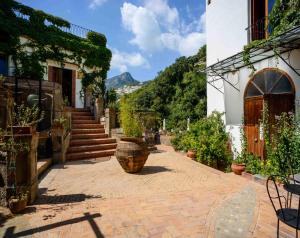 维耶特里纳雅迪山谷度假屋的一座庭院,里面种有盆栽植物,楼梯在建筑里