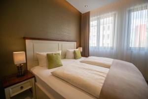 莱比锡莱比锡中央公寓式酒店的卧室配有一张大白色床和窗户