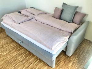 哥本哈根Villa Stjerneklar的一张带粉色和灰色毯子和枕头的床