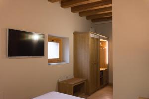 洛迪赛斯蒙内斯酒店的卧室配有壁挂式平面电视。