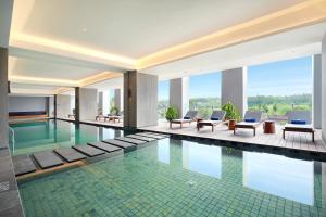 外南梦Kokoon Hotel Banyuwangi的一座配有桌椅的酒店游泳池