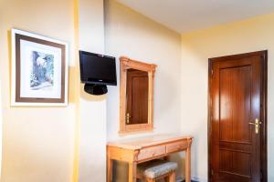 ChauchinaHotel El Cruce Chauchina的客房设有书桌和墙上的电视