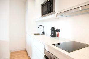 马德里1 bedroom 1 bathroom furnished - Salamanca - executive style - MintyStay的白色的厨房配有水槽和微波炉