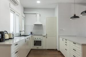 马德里MintyStay - Paseo de las Delicias的厨房配有白色橱柜和炉灶烤箱。
