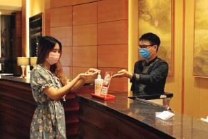 胡志明市Equatorial Ho Chi Minh City的一名男子和一名女子在柜台戴面具