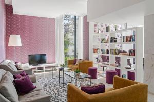丰沙尔Estrelicia Hotel的客厅配有紫色家具和电视