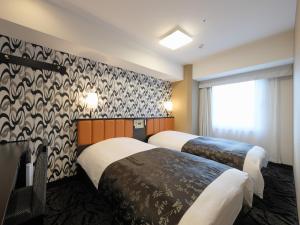东京APA Hotel Nihombashi Bakuroyokoyama Ekimae的酒店客房设有两张床和窗户。
