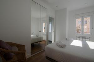 马德里2 bedrooms 2 bathrooms furnished - Bernabeu - Business area with terrace - Minty Stay的白色卧室配有床和镜子