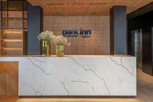 维尔纽斯Park Inn by Radisson Vilnius Airport Hotel & Conference Centre的大堂设有大理石台面,上面有鲜花