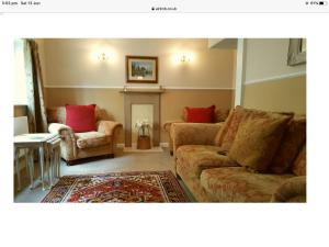 莱德伯里1 The Mews Cottages的客厅配有沙发和两把椅子