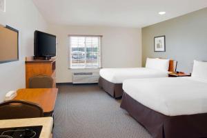 马纳萨斯WoodSpring Suites Manassas Battlefield Park I-66的酒店客房设有两张床和一台平面电视。