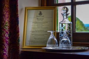 达尔比蒂The Lady Maxwell Room at Buittle Castle的玻璃瓶和窗边桌子上的花瓶