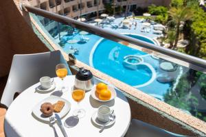 英格兰海滩MUR Apartamentos Buenos Aires Gran Canaria的一张桌子,旁边放着橙汁和食物杯,