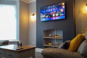 布莱克浦Westcliffe House的客厅配有沙发和墙上的电视