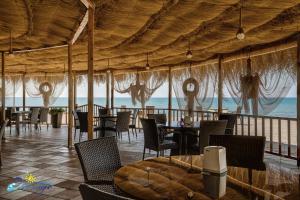 谢赫维蒂利Mirage Hotel的一间带桌椅的海景餐厅