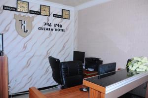 亚的斯亚贝巴Guzara Hotel Addis的办公室,配有桌椅和墙上的时钟