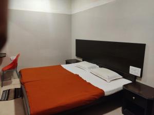 钦奈Hotel Sarada Nivas的一间卧室配有一张带橙色毯子的床