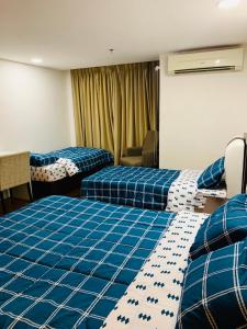 哥打巴鲁哥打巴鲁市点留宿公寓的酒店客房,配有两张带蓝色床单的床