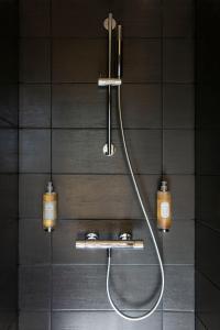 BreitenbachHôtel 48°Nord & Restaurant, The Originals Relais的浴室设有淋浴,墙上有两盏灯