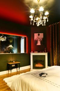 南希MoonLOVE, SPA/Sauna et Jacuzzi privés, charme et détente.的一间卧室配有一张床和一个壁炉