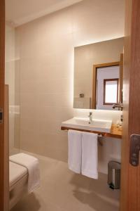 普里什蒂纳Grand Boutique Hotel的白色的浴室设有水槽和镜子