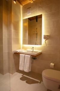 普里什蒂纳Grand Boutique Hotel的一间带水槽、卫生间和镜子的浴室