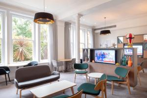 法恩伯勒假日法恩堡酒店的客厅配有家具、电视和窗户。