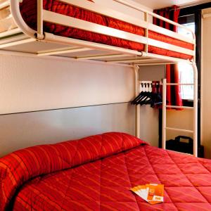 盖雷普瑞米尔杰雷经典酒店的一间卧室配有一张红色棉被的床